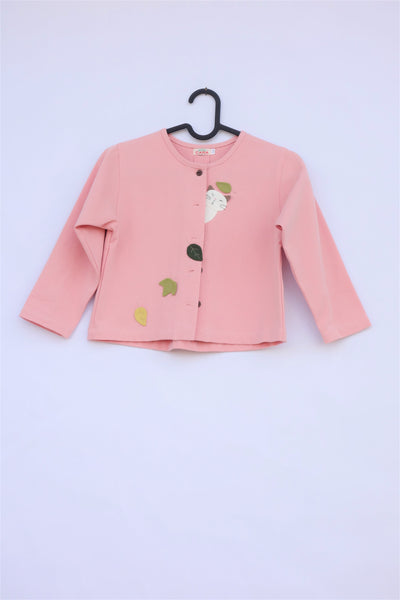 A pink girlsâ boxy-fit cotton cat jacket on a hanger with appliquĂ© cat and leaves on the front. There are buttons on the jacket.