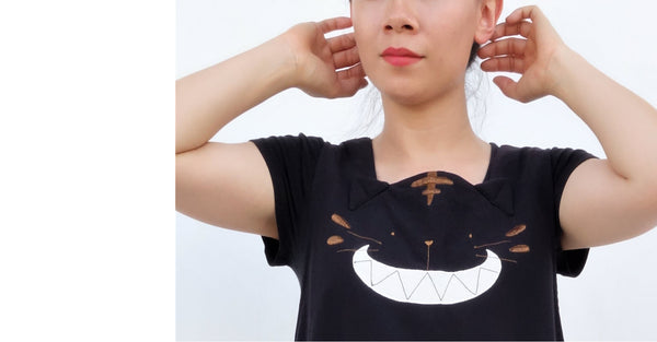 Woman wearing a cat dress with large, stitched-on, cat smile applique.