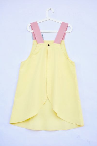 Pink and yellow color-blocked apron with cat appliqué, large front pocket, in back, flat view.