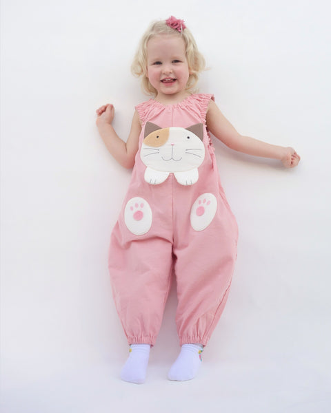 Girl wearing pink, cat-themed jumper with large, soft cat face pocket and cat paws in the front, two little fish friends swim on the back, sewn appliqué, embroidery details and side pockets in front view.