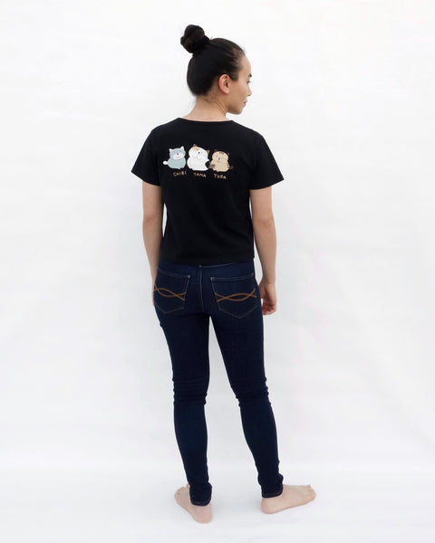 Woman wearing Cat Crop Top in black with three cat appliqué, embroidery details, V-neck and short sleeves in full-body, close-up back view.