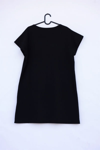 Woman's black, cat shift-dress with short sleeves, rounded neck opening, on hanger, in back view.