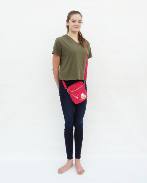 Woman wearing olive green, Cat Crop Top with V-neck, short sleeves and cat crossbody purse in full-body front view.