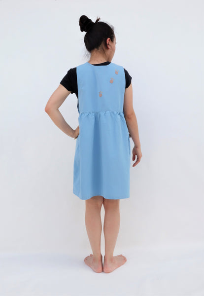 Woman wearing blue sleeveless cat dress with cat pawprints up the back of the dress