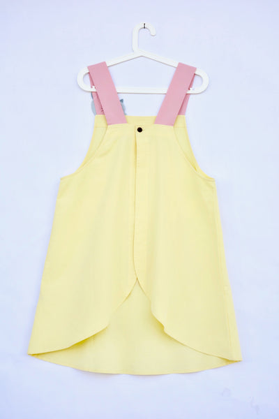 Pink and yellow color-blocked apron with cat appliqué, large front pocket, in back, flat view.