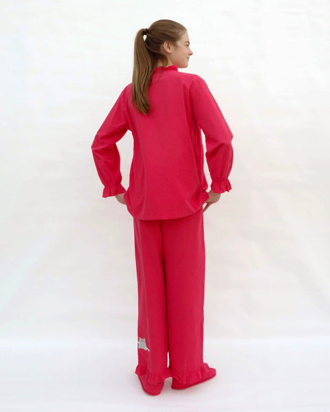 Women wearing red pajamas with cat appliqué, embroidery details, and matching slippers in back view.