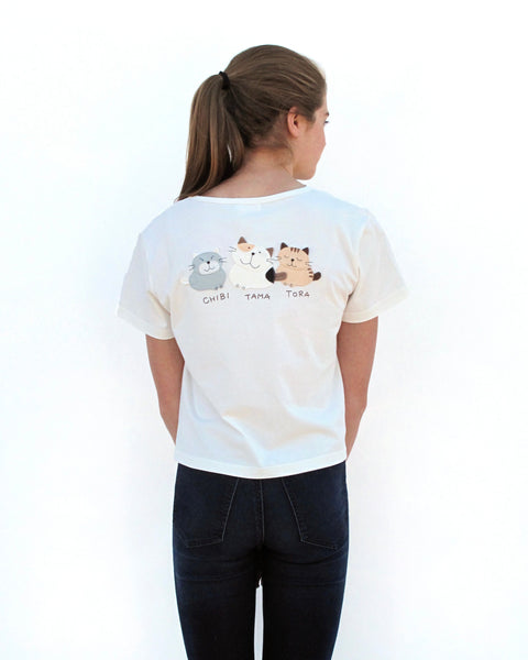 Woman wearing Cat Crop Top in white with three cat appliqué, embroidery details, V-neck and short sleeves in close-up back view.