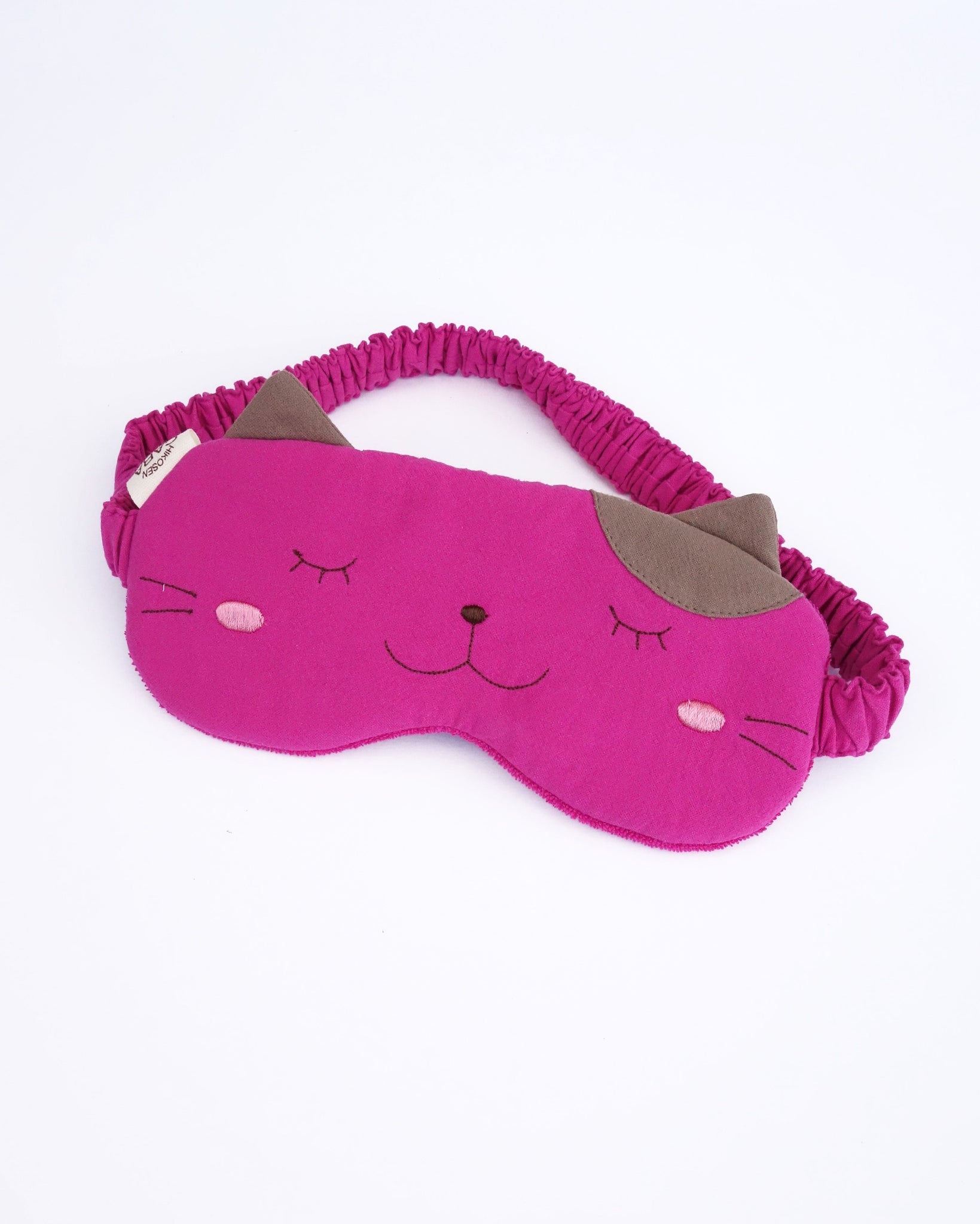 Eye mask in fushsia color with appliqué, embroidery, 3D cat ears, elastic strap, foam-padding,  in front view.