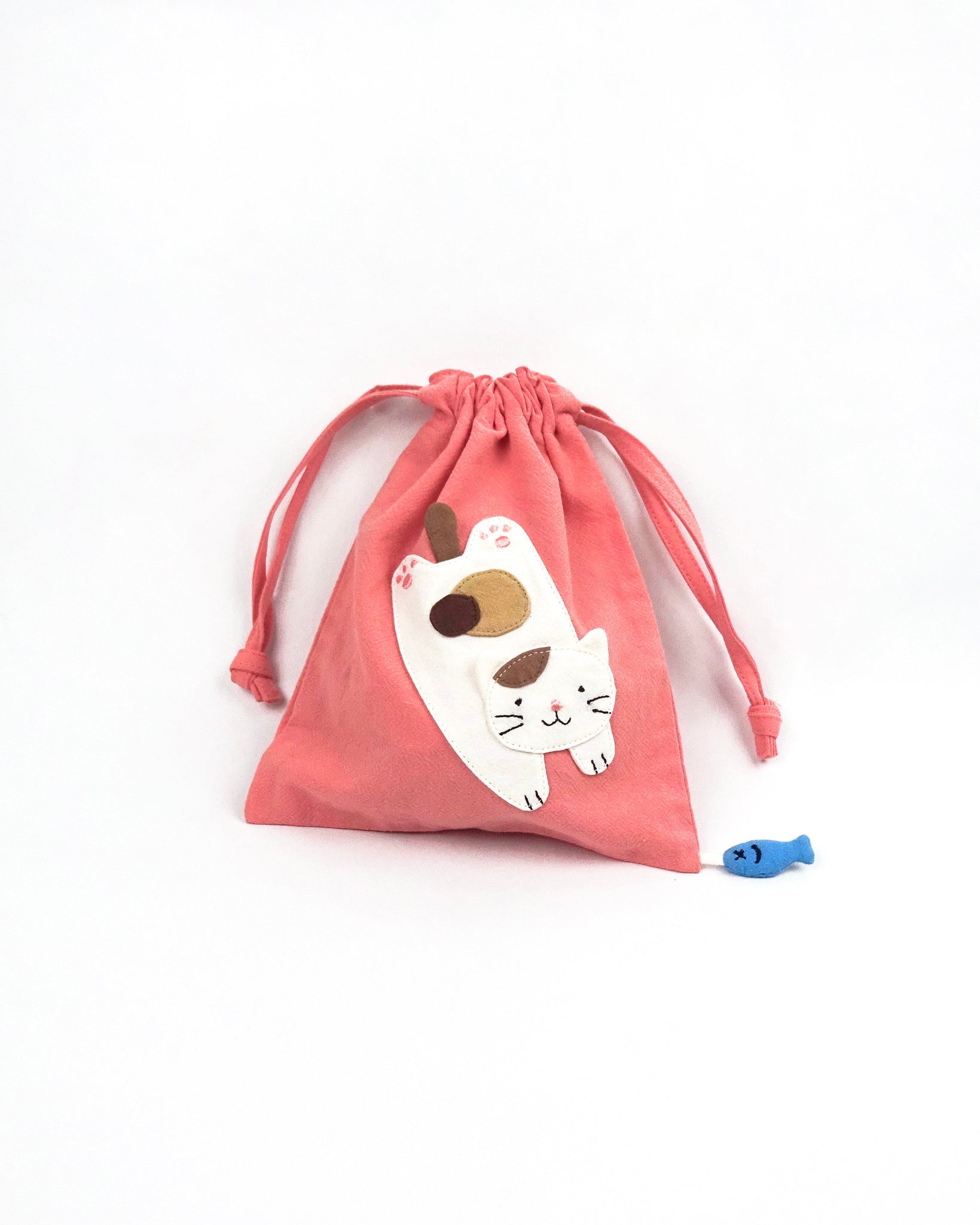 Cat Pouch in pink with cat appliqué, embroidery detail, two-sided drawstring enclosure, small blue fish hanging at the bottom right corner.